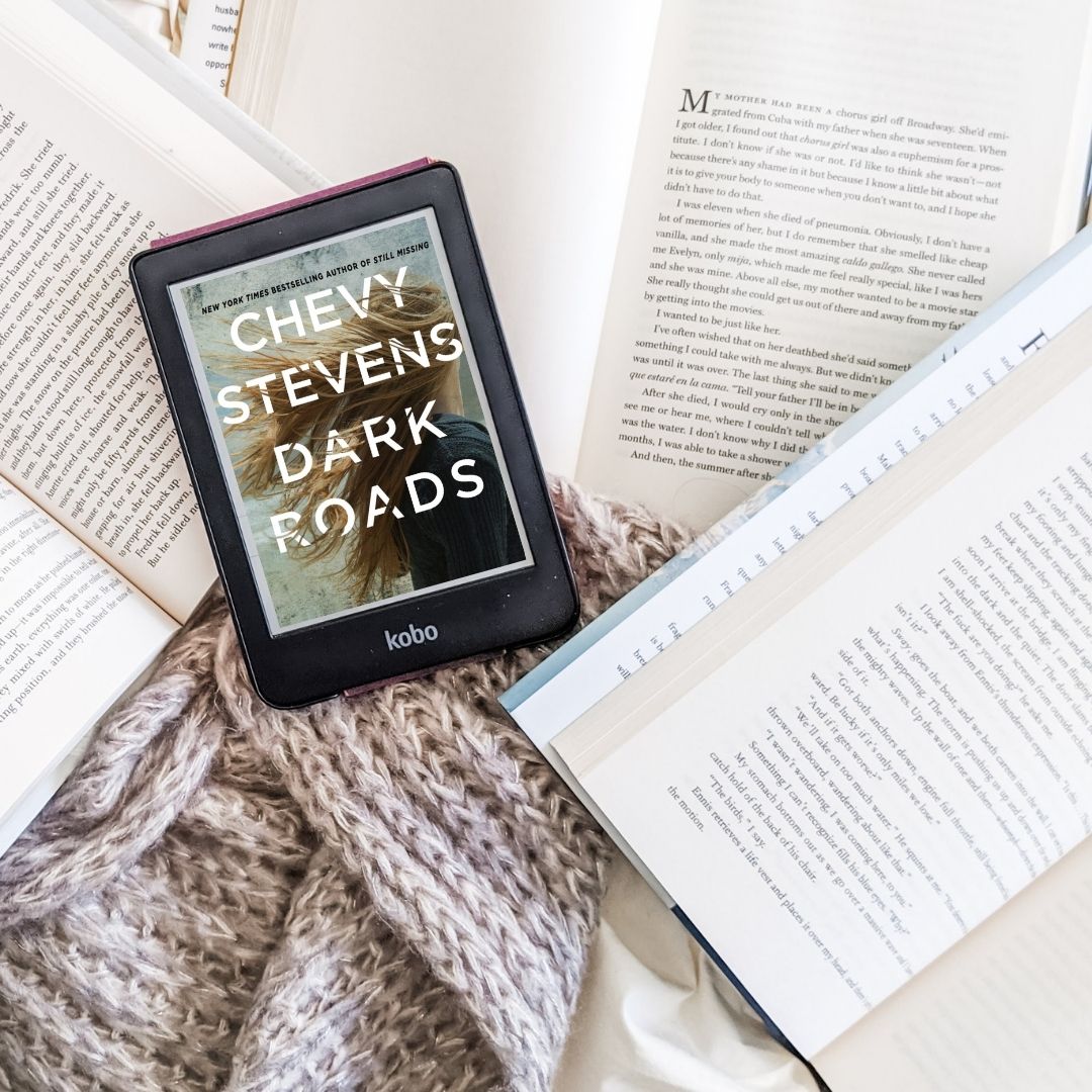 Dark Roads by Chevy Stevens book cover on e-reader, set amidst other open books